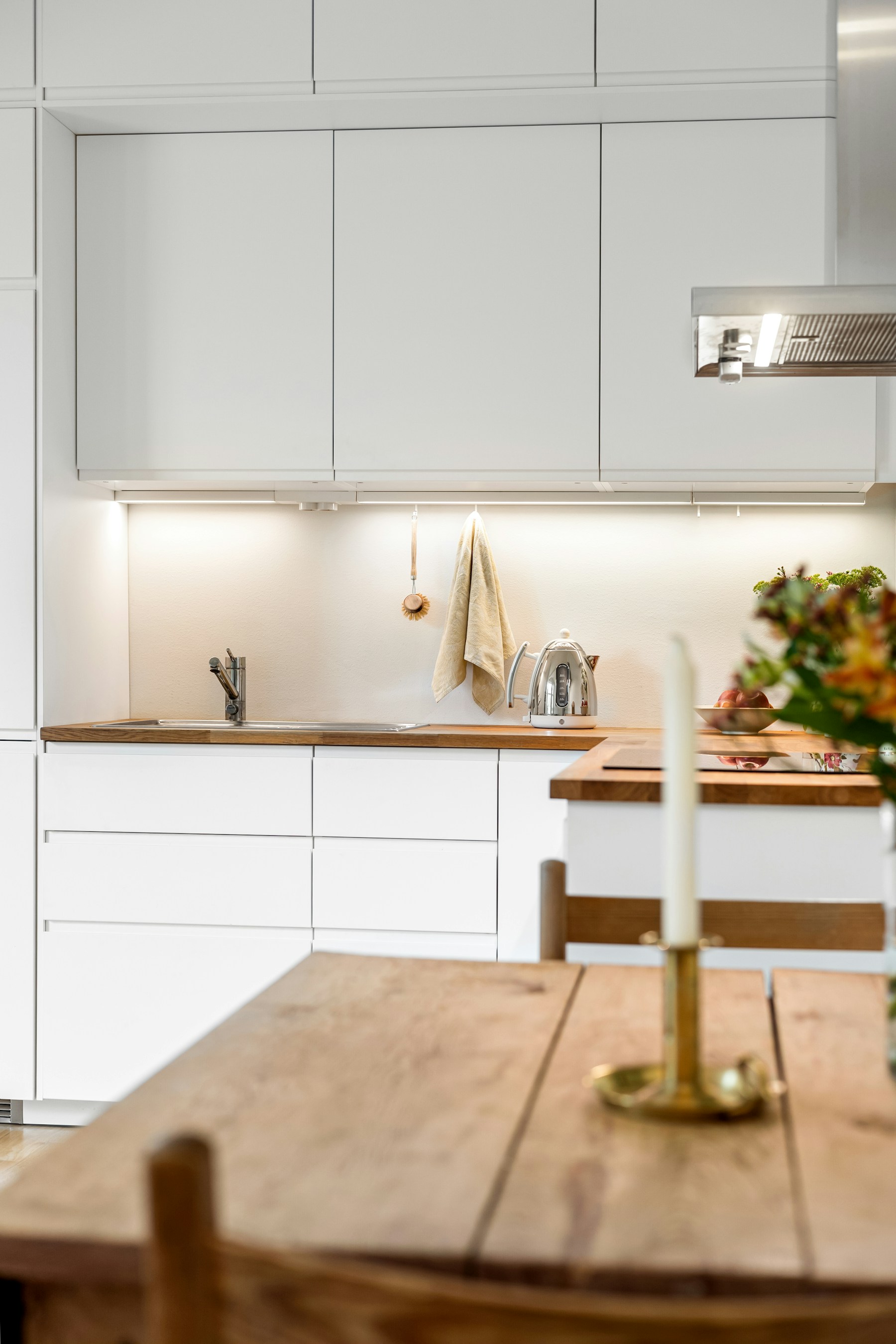 Lichte keuken met houten werkblad en witte kasten