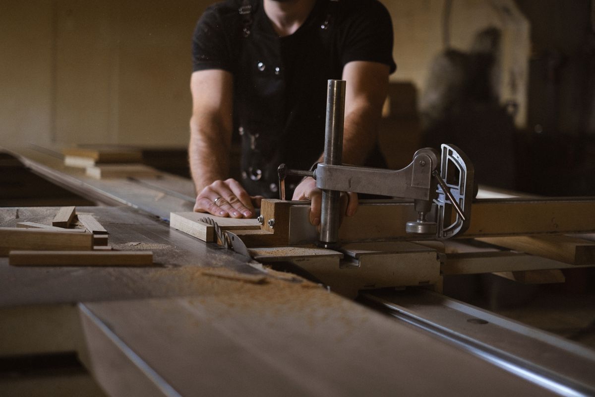 Timmerman aan het werk met hout in zijn werkplaats